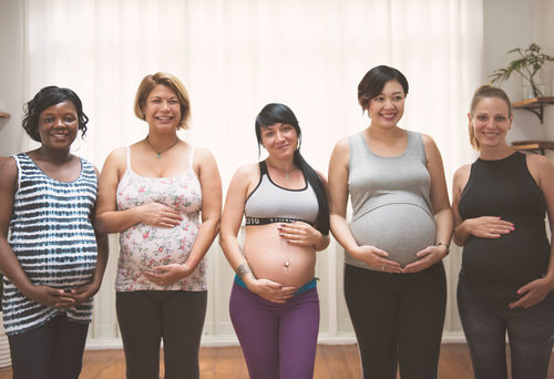 Group of pregnant women meeting, one looking confidently at the camera and smiling. Group and individual pregnancy and postpartum counseling services in Ewing, NJ will help you feel more prepared to thrive with your new baby. 